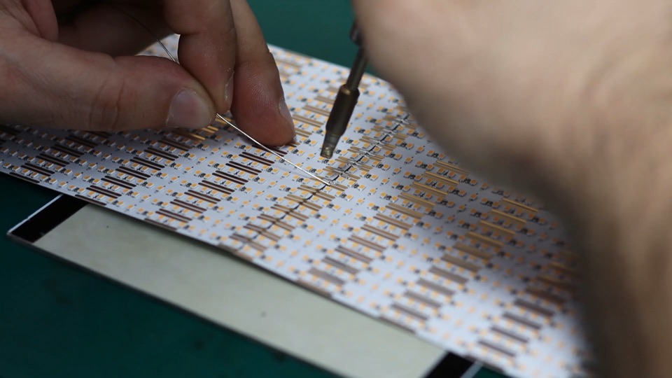 Hand soldering on an LED strip circuit board